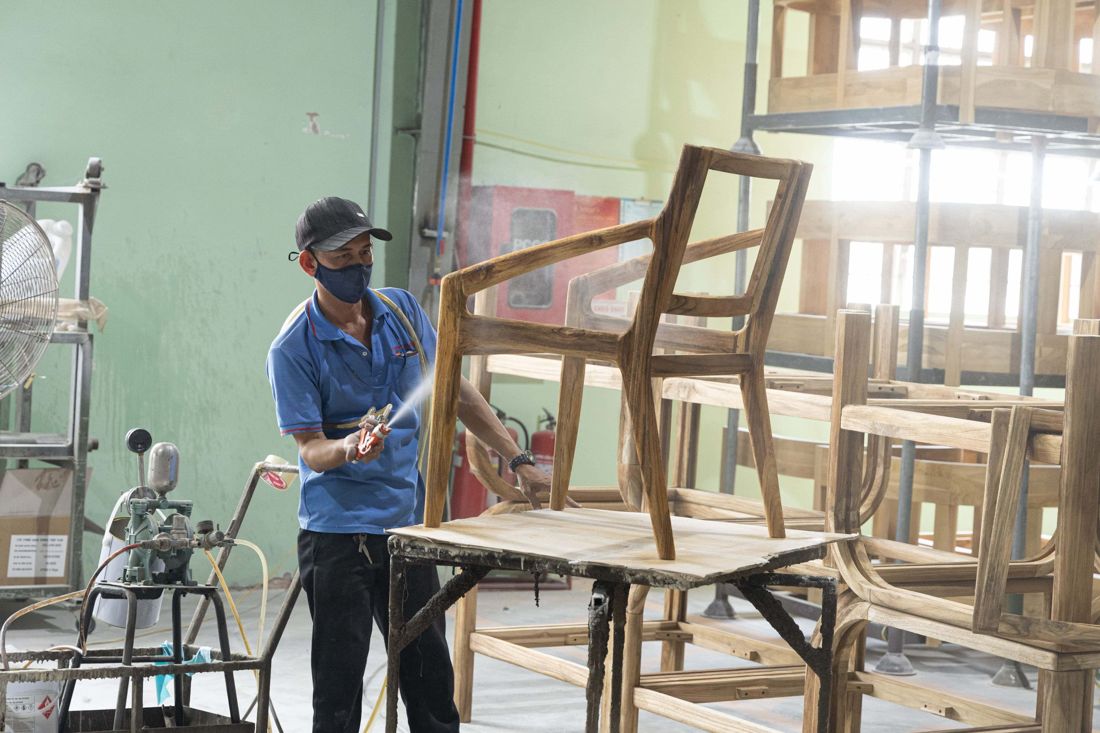 Thợ thủ công đang hoàn thiện khung ghế mây bằng tay